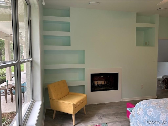 5774 N Lamp Post Dr, Beverly Hills, FL 34465 - bedroom with multiple windows, wood finished floors, and a glass covered fireplace