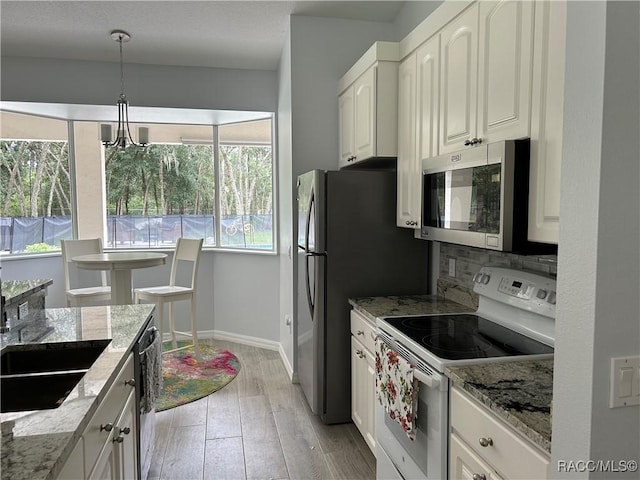 5774 N Lamp Post Dr, Beverly Hills, FL 34465 - kitchen featuring appliances with stainless steel finishes, light stone countertops, light wood-type flooring, and hanging light fixtures