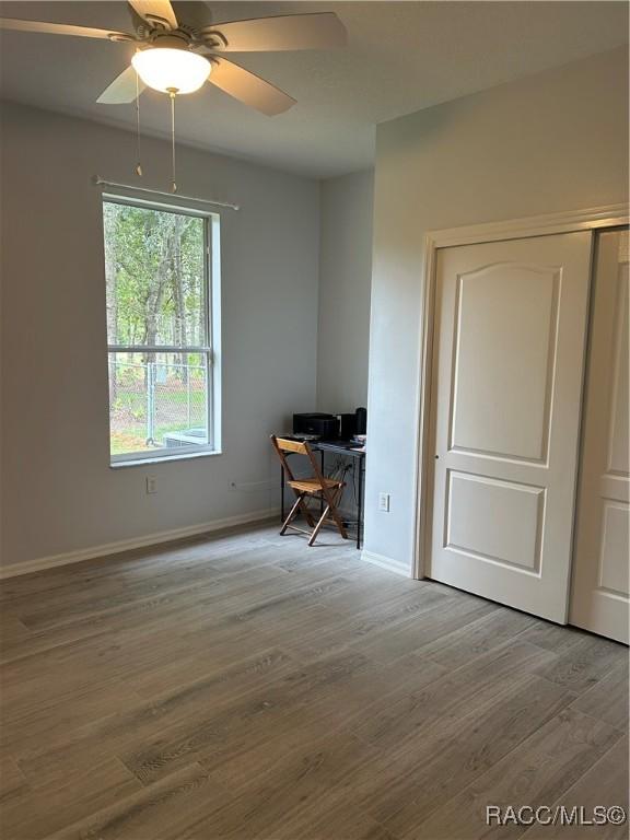 5774 N Lamp Post Dr, Beverly Hills, FL 34465 - unfurnished room with a desk, wood finished floors, and a ceiling fan