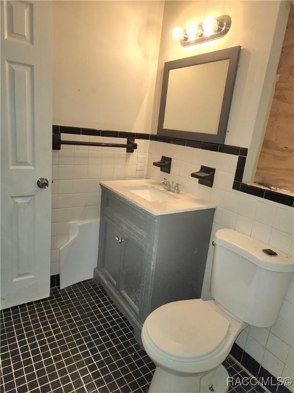 1408/1410 NE 15th Pl, Ocala, FL 34470 - bathroom with tile walls, vanity, wainscoting, and tile patterned flooring