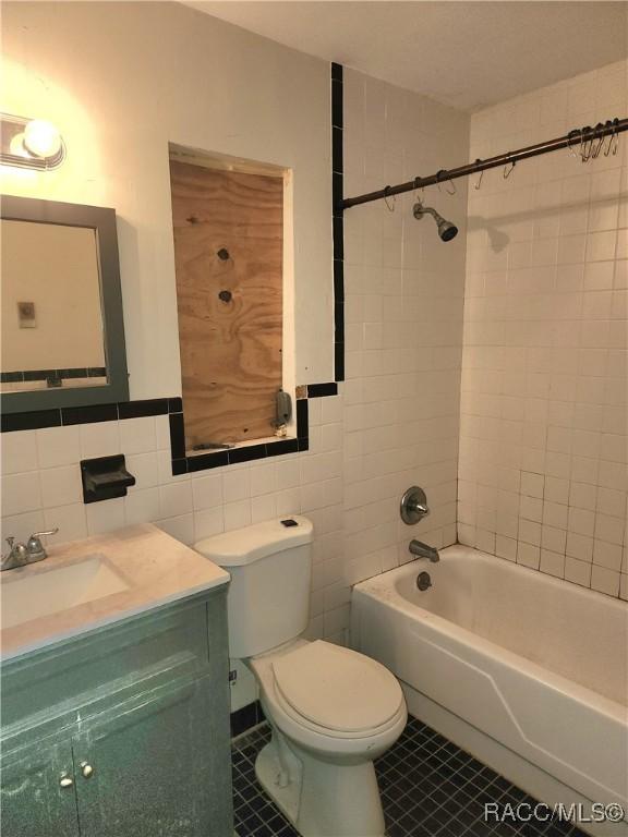 1408/1410 NE 15th Pl, Ocala, FL 34470 - bathroom featuring tile walls, tile patterned floors, vanity, and  shower combination