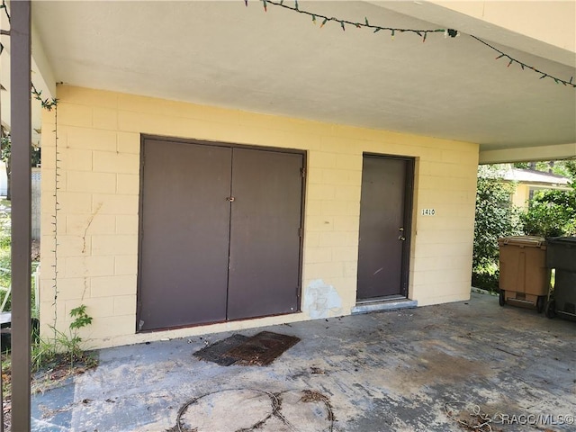 1408/1410 NE 15th Pl, Ocala, FL 34470 - view of exterior entry with concrete block siding and a patio