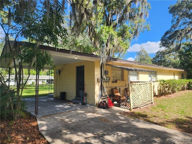 1408/1410 NE 15th Pl, Ocala, FL 34470 - rear view of property with driveway, concrete block siding, entry steps, a carport, and a yard