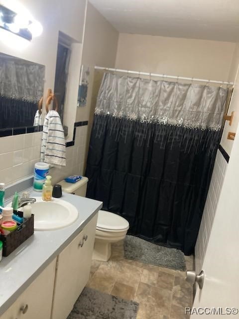 1408/1410 NE 15th Pl, Ocala, FL 34470 - full bath featuring tile walls, vanity, a shower with curtain, and stone finish flooring