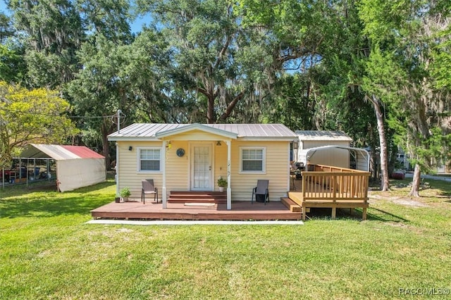 view of front facade featuring a storage unit, a deck, and a front yard