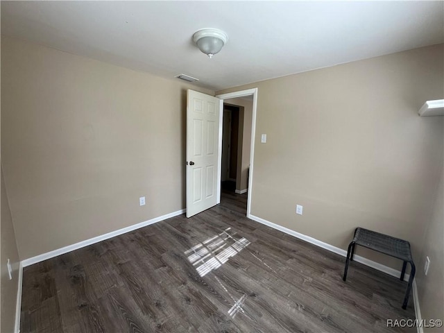 spare room featuring dark wood-type flooring