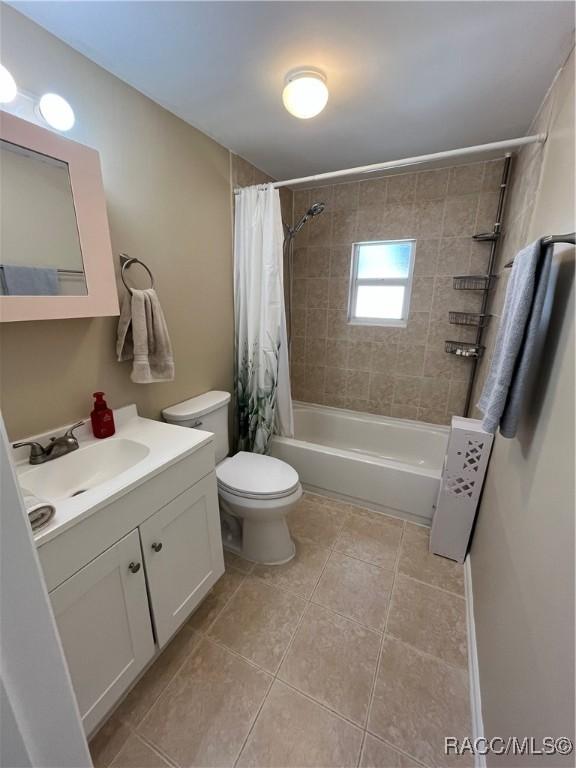 full bathroom featuring toilet, vanity, and shower / bath combo with shower curtain