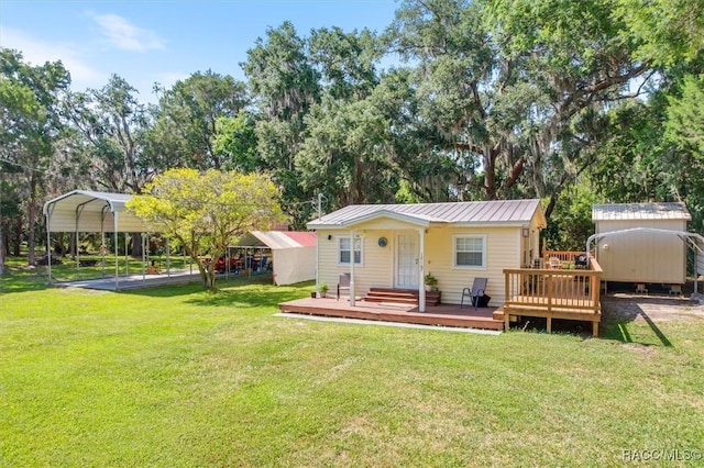 back of house with a storage unit, a deck, a carport, and a yard