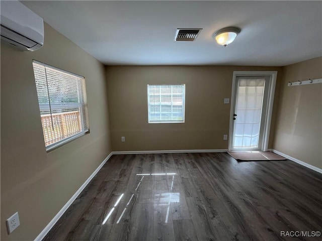 entryway featuring an AC wall unit, dark wood-type flooring, and plenty of natural light