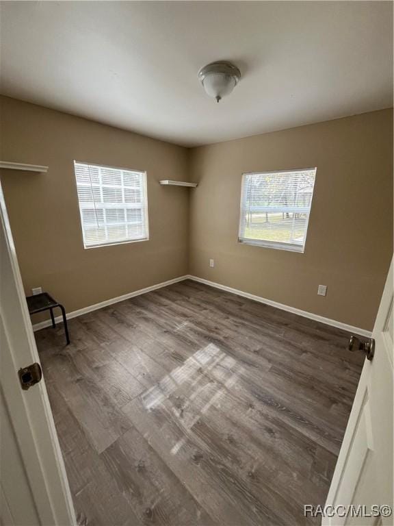 unfurnished room with hardwood / wood-style flooring and a healthy amount of sunlight