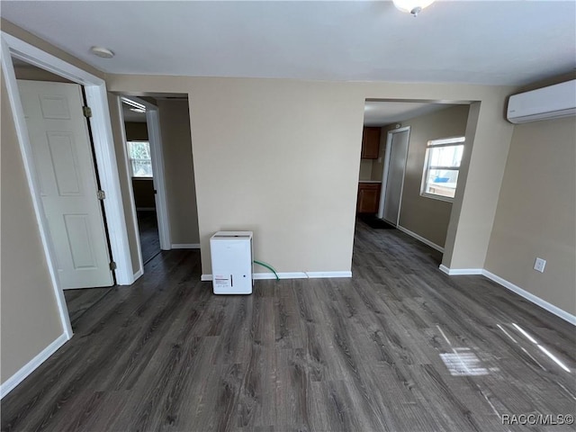 spare room featuring dark hardwood / wood-style floors and a wall mounted air conditioner