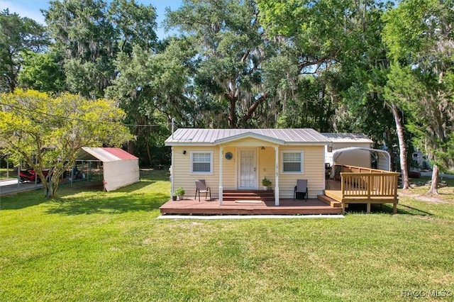 view of front of property with an outbuilding, a front lawn, a deck, and a carport