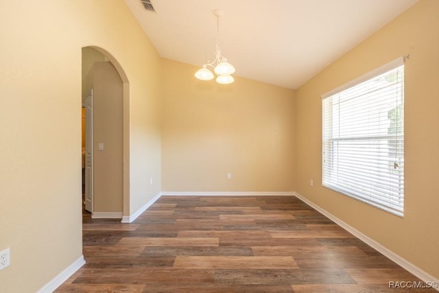 empty room with visible vents, arched walkways, a notable chandelier, wood finished floors, and vaulted ceiling