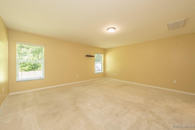 unfurnished room featuring light carpet, visible vents, and baseboards