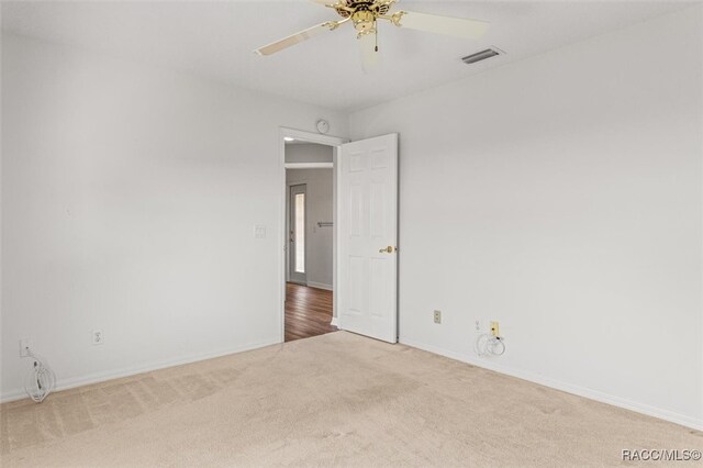 unfurnished room featuring light colored carpet and ceiling fan