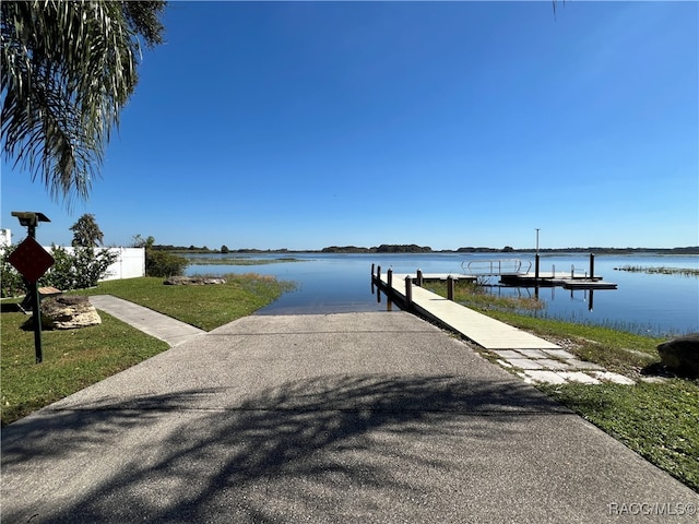 view of dock featuring a yard and a water view