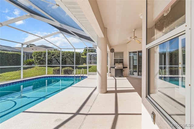 view of swimming pool with a lanai, a patio area, ceiling fan, and a grill