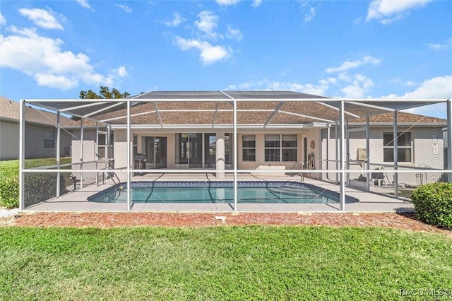 rear view of house with a lanai, a patio area, and a lawn