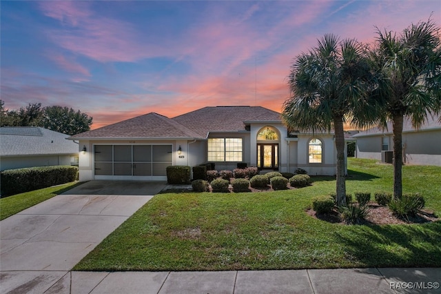 view of front of house with a garage, a yard, and french doors