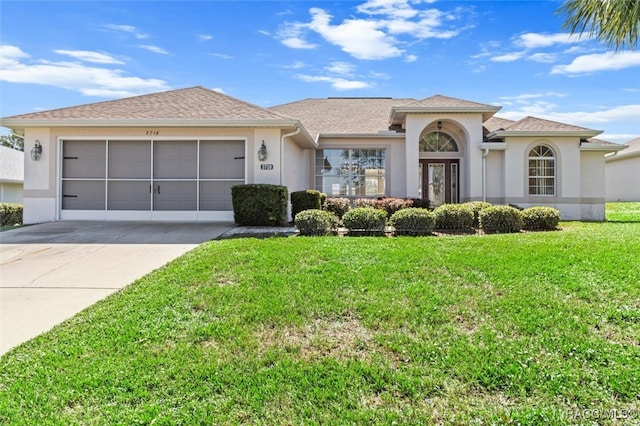 view of front of house featuring a garage and a front lawn