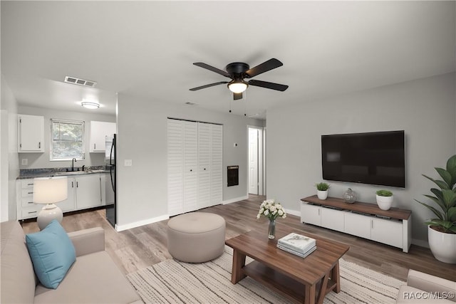 living room with ceiling fan, wood-type flooring, and sink