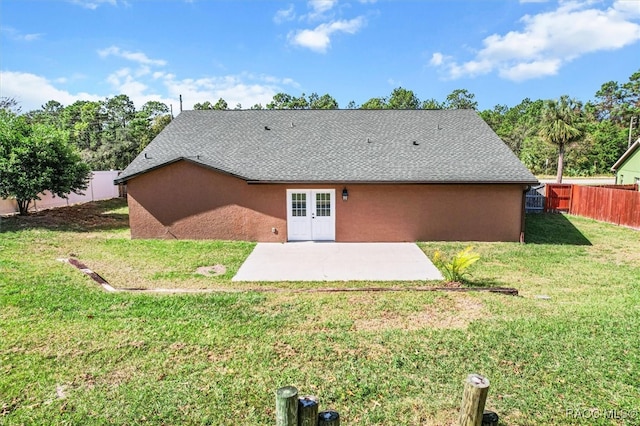 back of property featuring a patio area and a lawn