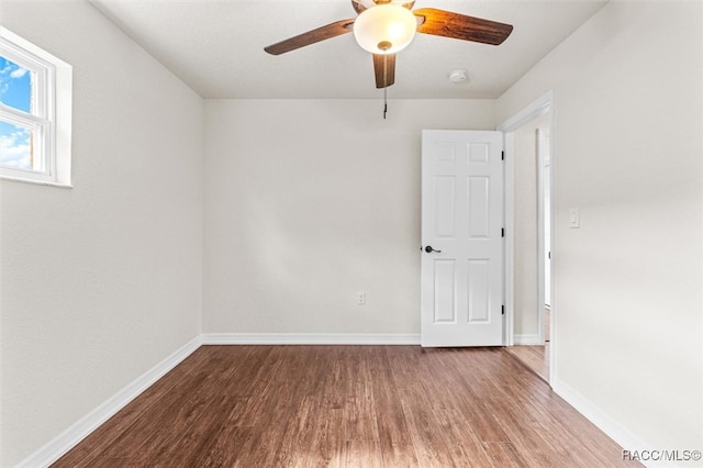 empty room with hardwood / wood-style floors and ceiling fan