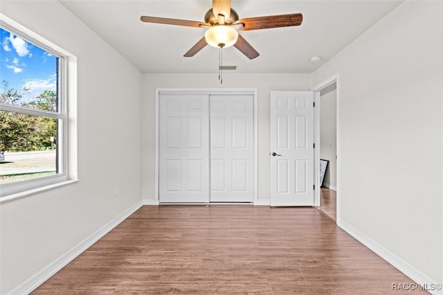 unfurnished bedroom with light wood-type flooring, a closet, and ceiling fan