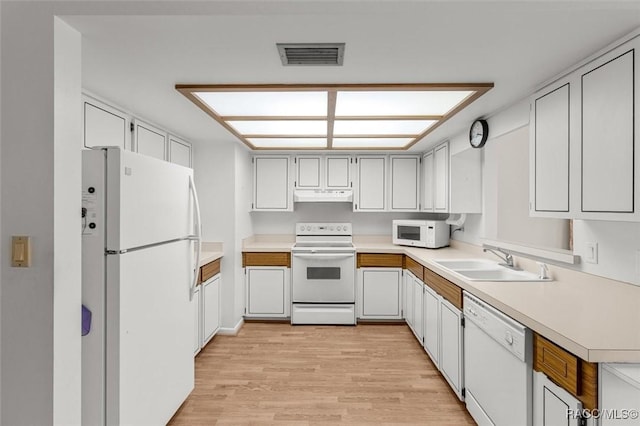 732 Wharton Ter, Inverness, FL 34450 - kitchen featuring white appliances, under cabinet range hood, light wood-type flooring, and light countertops