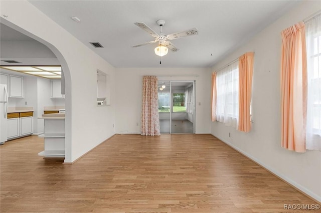 732 Wharton Ter, Inverness, FL 34450 - unfurnished living room featuring light wood-type flooring, a ceiling fan, and arched walkways