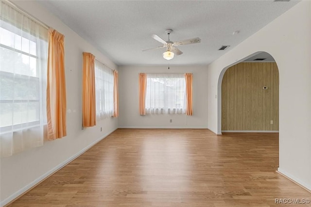 732 Wharton Ter, Inverness, FL 34450 - empty room with ceiling fan, wood finished floors, arched walkways, and a textured ceiling