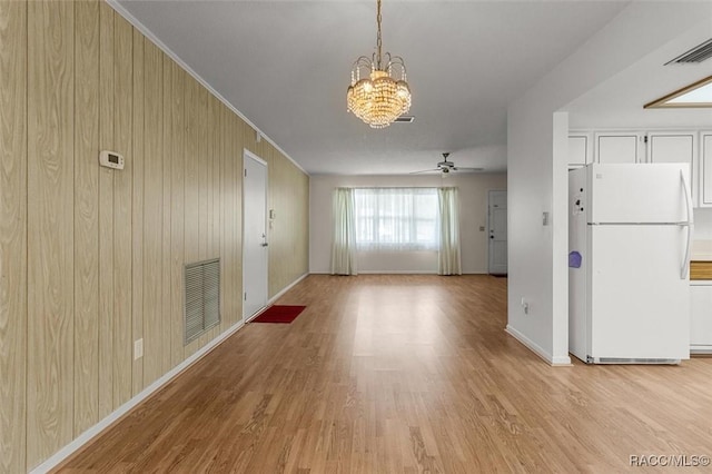 732 Wharton Ter, Inverness, FL 34450 - unfurnished living room with a chandelier, light wood finished floors, a ceiling fan, and wooden walls