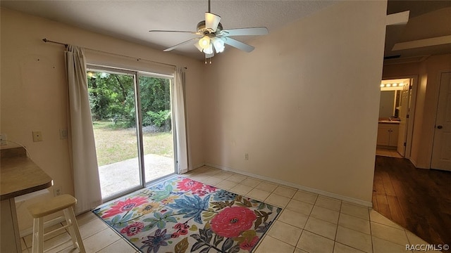 doorway to outside with light tile patterned floors, a textured ceiling, and ceiling fan