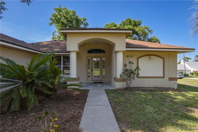 604 Morse St, Inverness, FL 34452 - property entrance featuring a yard, stucco siding, and a shingled roof