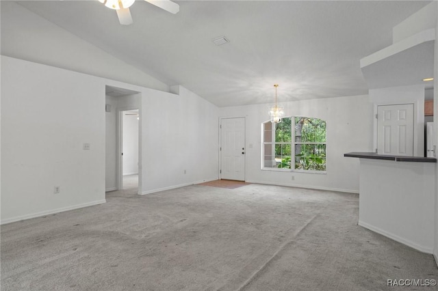 unfurnished living room with baseboards, carpet, ceiling fan with notable chandelier, and visible vents