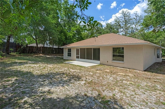 rear view of property with fence, a patio, and stucco siding