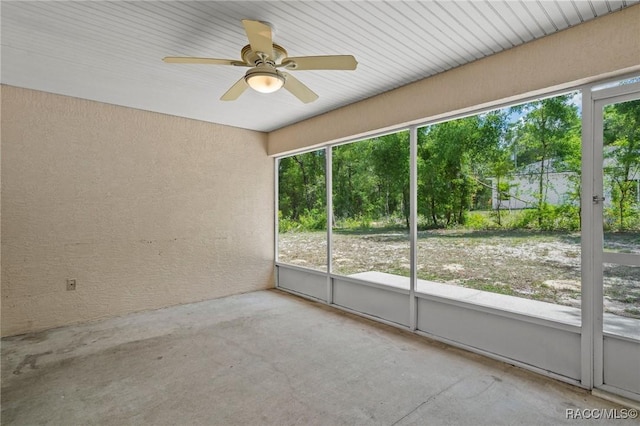 empty room with ceiling fan and concrete floors