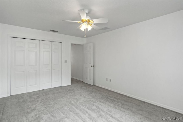 unfurnished bedroom with a closet, baseboards, carpet flooring, and visible vents