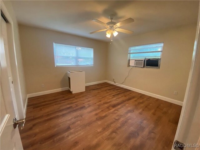 5175 E Tangelo Ln, Inverness, FL 34453 - unfurnished bedroom with dark wood-style flooring, baseboards, and a ceiling fan