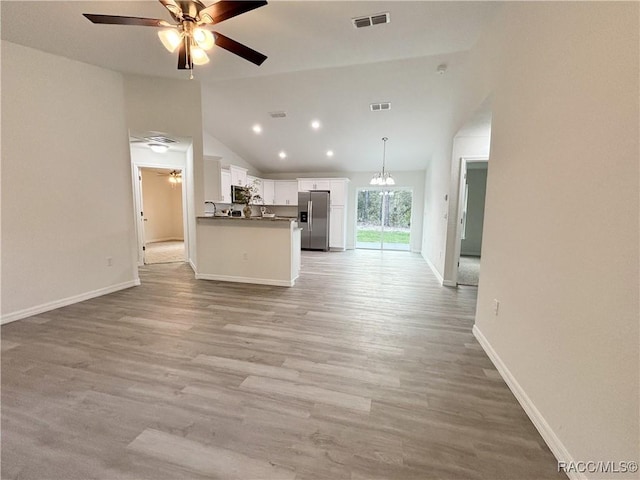 unfurnished living room featuring light wood-style floors, visible vents, and ceiling fan with notable chandelier