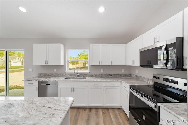 2114 W Magenta Dr, Citrus Springs, FL 34434 - kitchen featuring a sink, stainless steel appliances, a wealth of natural light, and white cabinetry