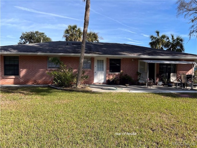 rear view of property featuring a yard and a patio