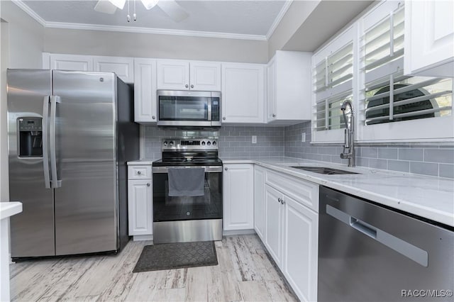 kitchen featuring white cabinetry, sink, light stone counters, and appliances with stainless steel finishes