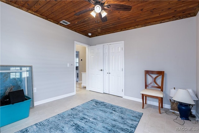 living area with ceiling fan, light tile patterned floors, and wooden ceiling