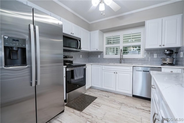 kitchen with white cabinetry, ornamental molding, stainless steel appliances, and sink