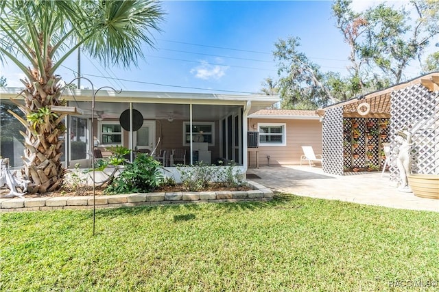 back of property with ceiling fan, a yard, a patio, and a sunroom