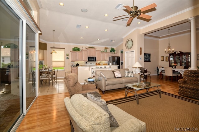 living room featuring ceiling fan with notable chandelier, vaulted ceiling, ornamental molding, and light hardwood / wood-style flooring