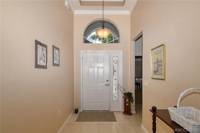 foyer with crown molding, a towering ceiling, and light tile patterned floors