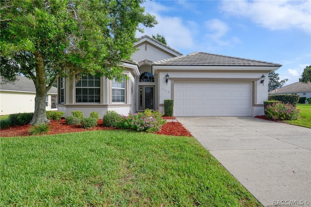 view of front of property with a front lawn and a garage