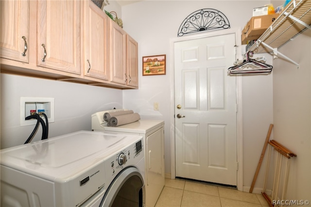 laundry area featuring cabinets, washer and dryer, and light tile patterned flooring